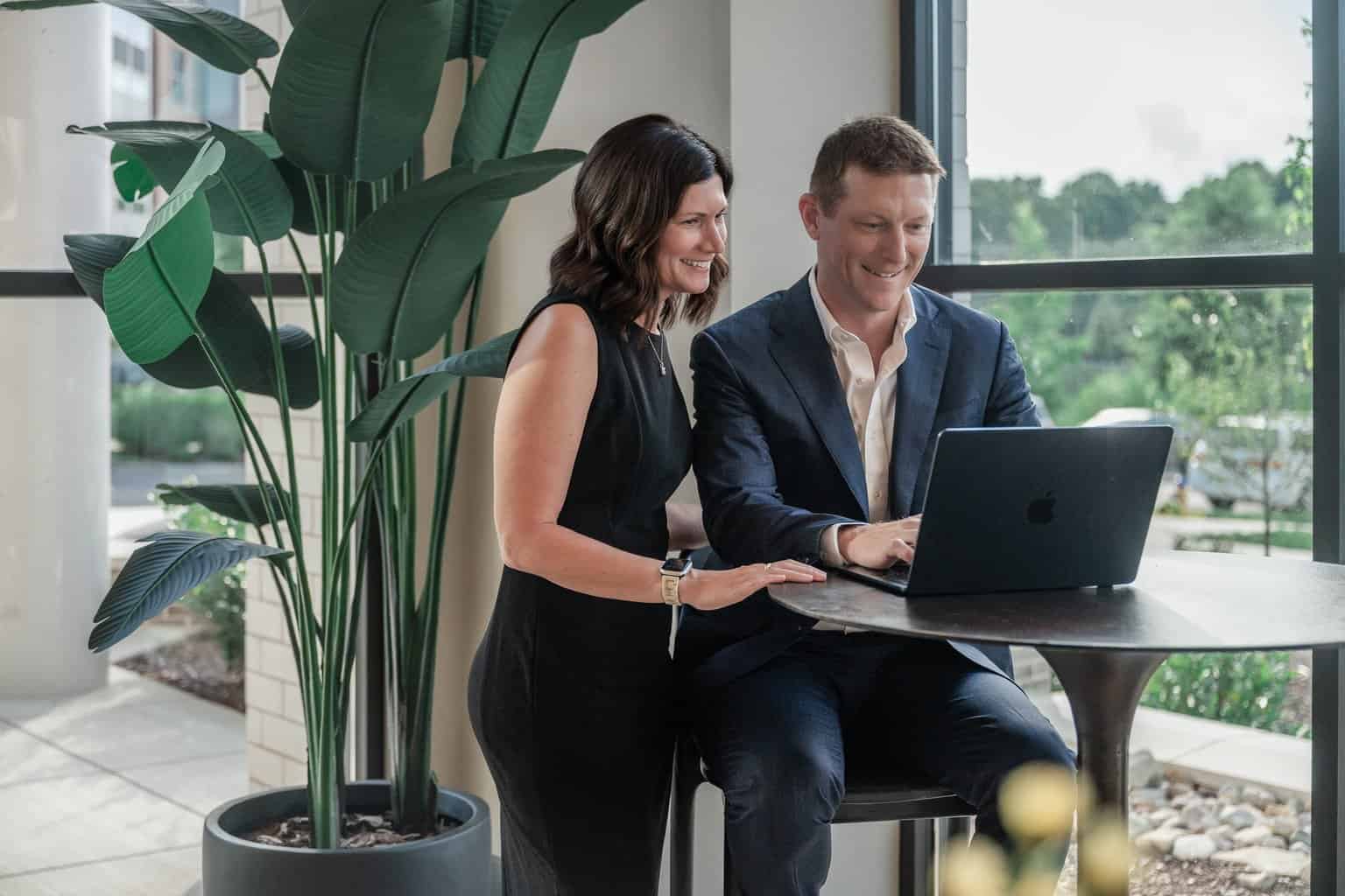 RL Hesson and his wife reviewing numbers on a laptop