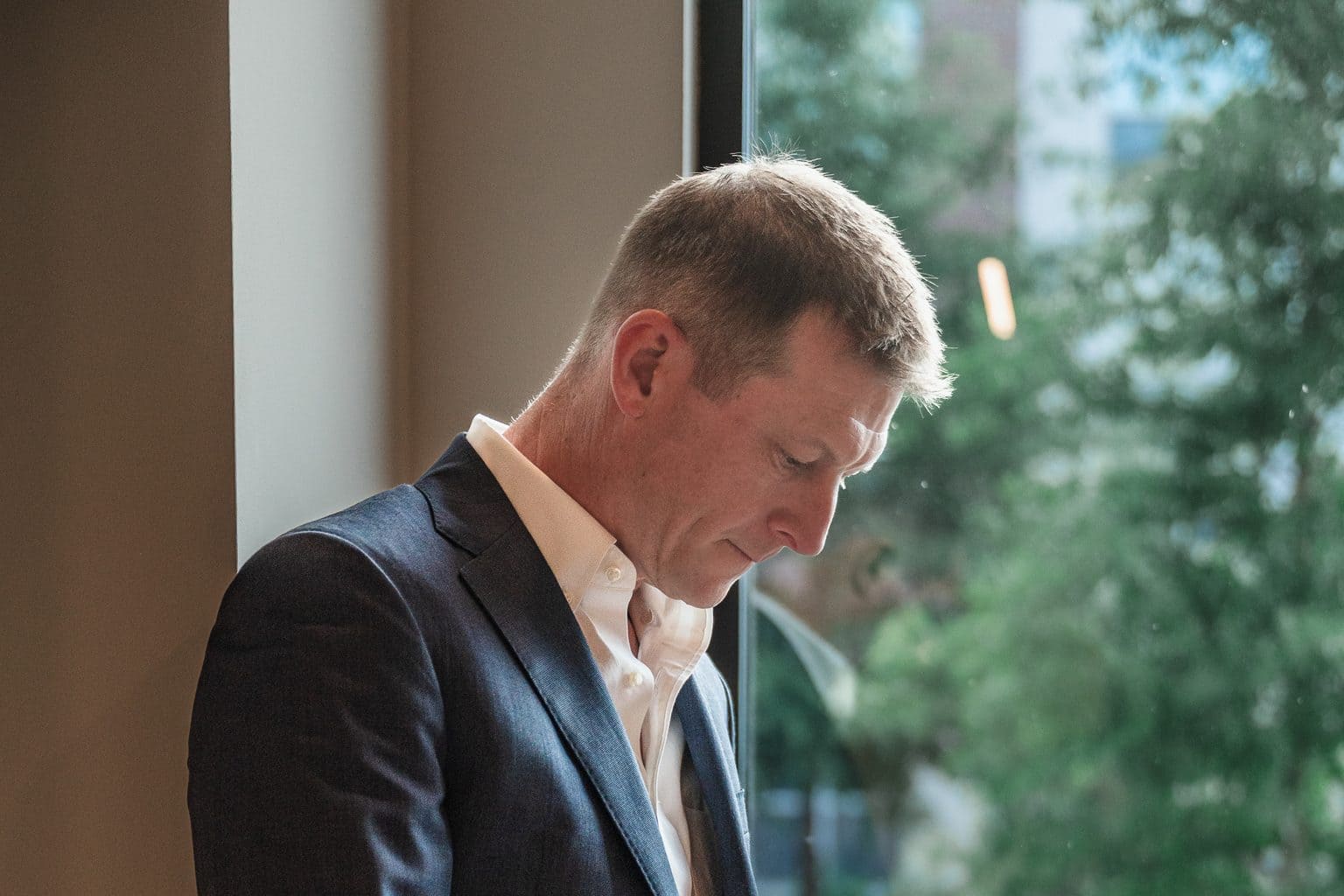 RL Hesson checking his phone by a window